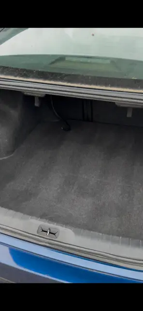 The same sedan trunk emptied, vacuumed and the carpet lifted clean