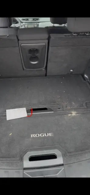 Nissan Rogue cargo area with litter and crumbs across the carpet liner